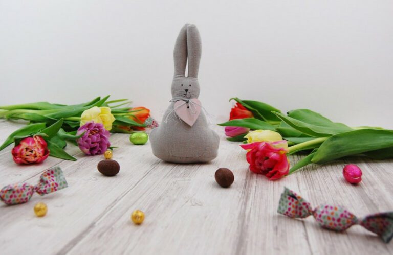 An Easter Bunny surrounded by spring flowers and sweets